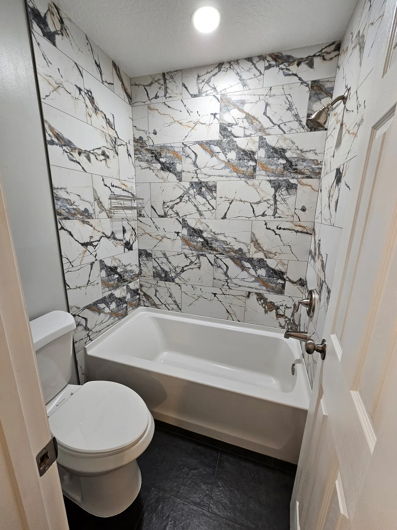 Cuarto de bañera revestido en porcelanato tipo mármol
