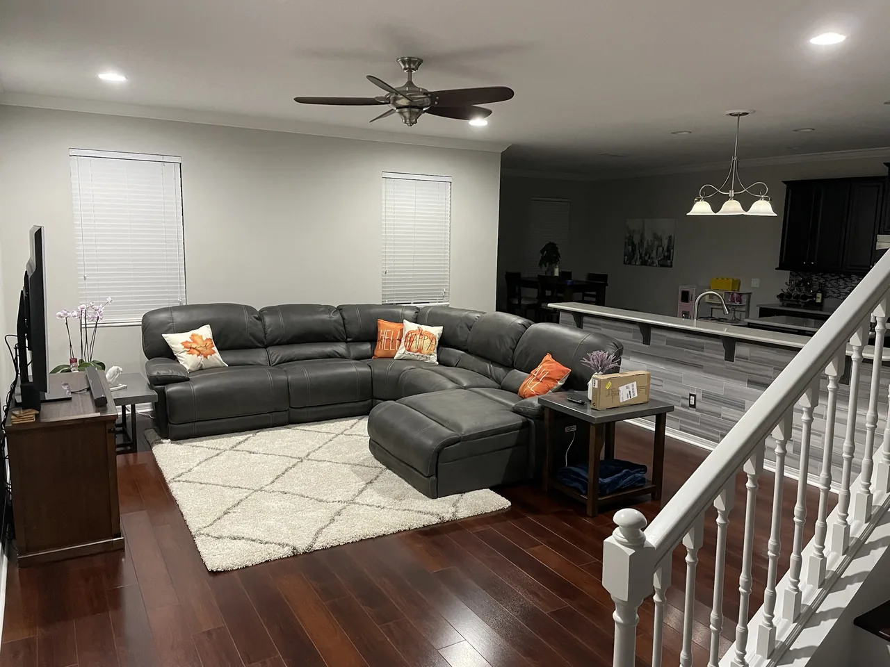 Before: dark laminate wood floor in an open living room and kitchen