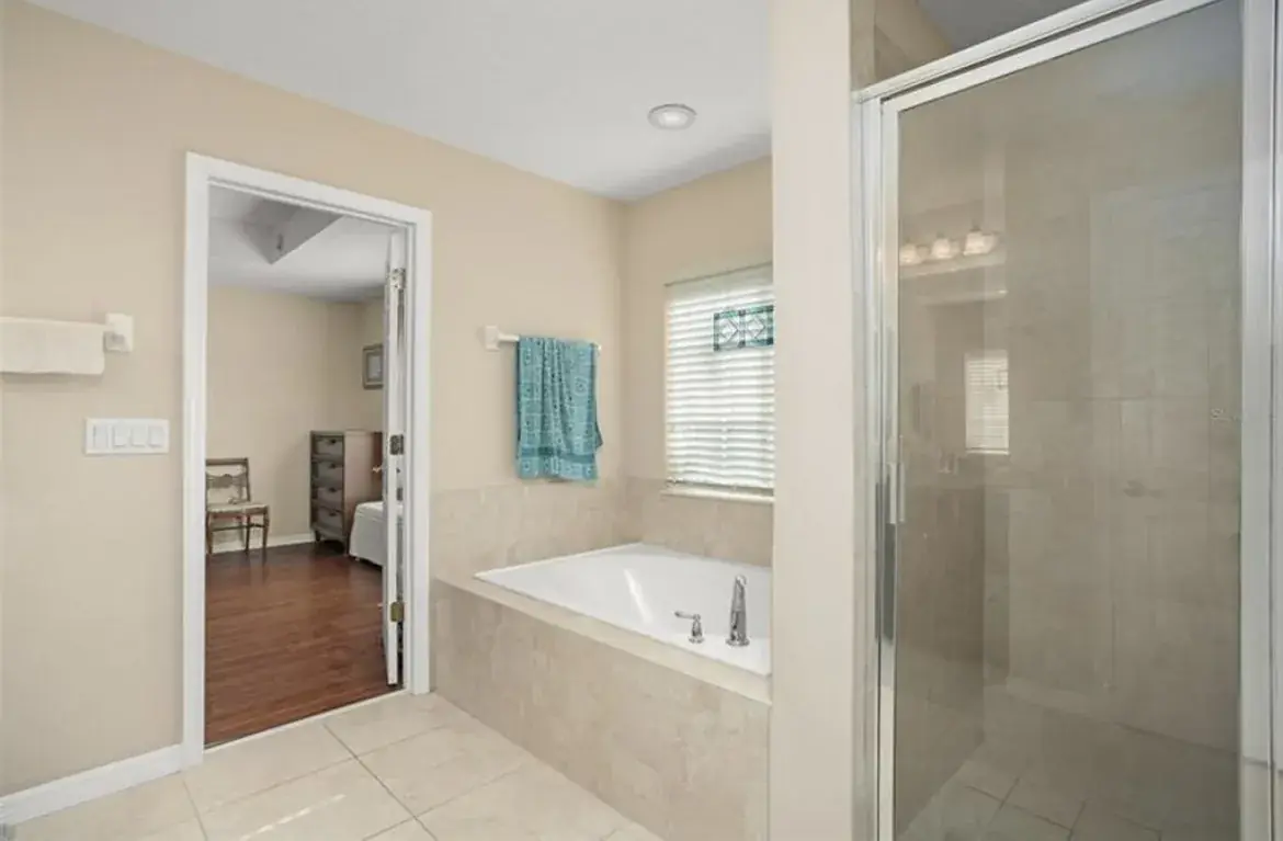 The bathroom before: tub, shower with glass door and original tile